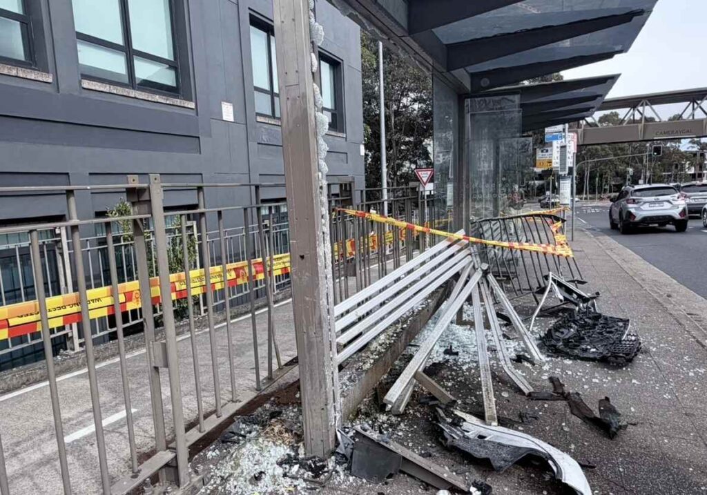 Shattered glass across the Lane Cove bus shelter as a bus passes on Longueville Road