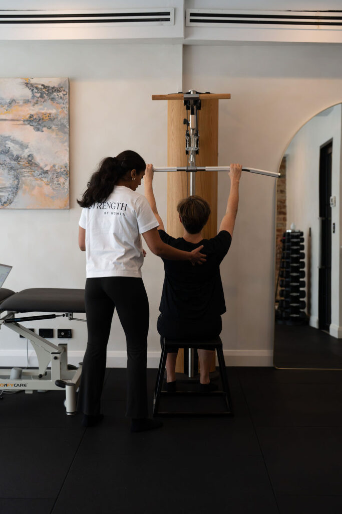 A woman strength training with an Exercise Physiologist at Strength By Women in Longueville