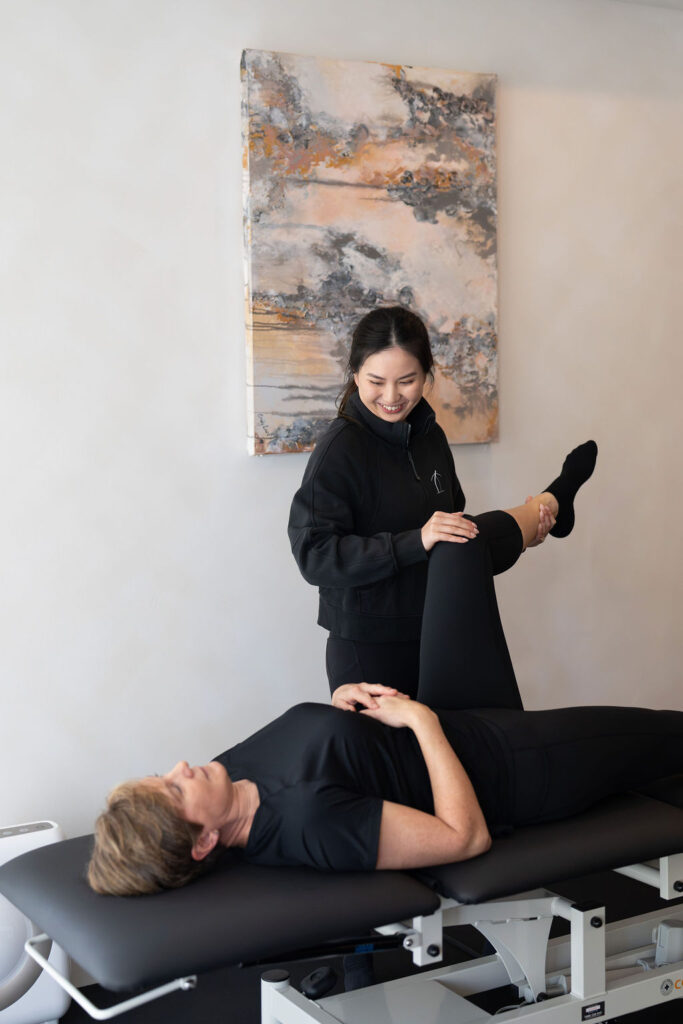 Exercise Physiologist guiding a woman through a resistance training exercise at Strength By Women