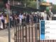 Commuters queuing at the Lane Cove bus stop on the Pacific Highway. An inset shows a real-time departure board with four consecutive route 253 services to Wynyard all running late.