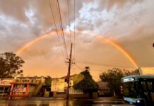 Rainbow over a wet Lane Cove street after Saturday's storm, with a 254 bus at the lights