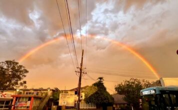 Rainbow over a wet Lane Cove street after Saturday's storm, with a 254 bus at the lights