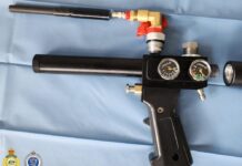 Airgun, drugs and steroids: Lane Cove West home raided in national firearms crackdown Black airgun with a carbon barrel and air cylinder standing upright in a cluttered room next to a printer