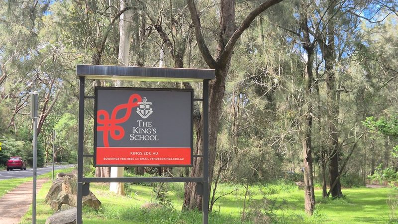 The King's School sign on posts among gum trees beside Lady Game Drive at the Naamaroo entrance