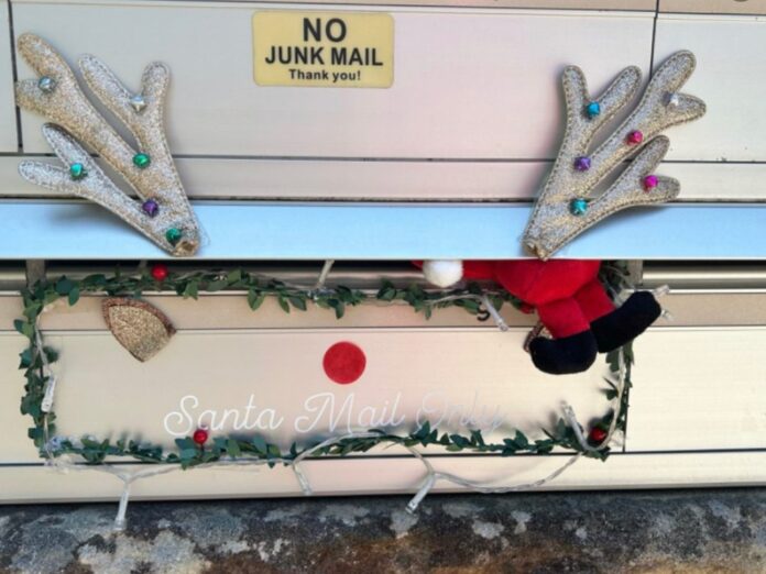 Letterbox decorated as a reindeer with glitter antlers, a red nose and a Santa toy, below a No Junk Mail sticker
