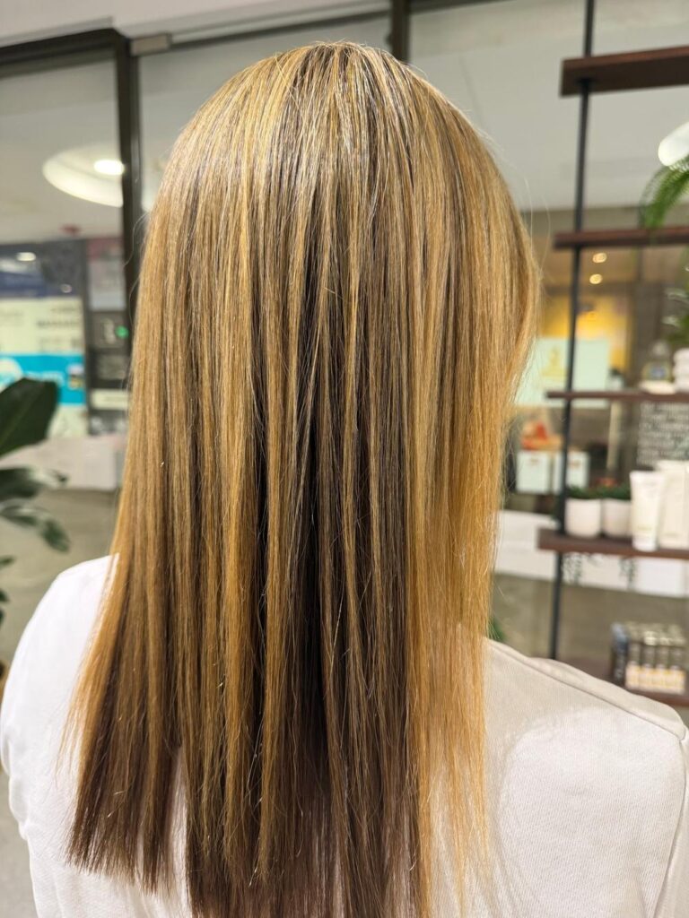 Straight hair with golden blonde highlights at K Avenue Hair & Beauty.