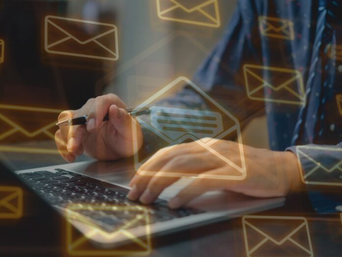 lane-cove-council-supplier-email-data-breach A person typing on a laptop with glowing email envelope icons floating around the screen.